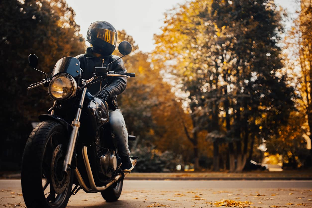 A person wearing a helmet sits on a motorcycle, highlighting safety regulations for Louisiana motorcycle riders.
