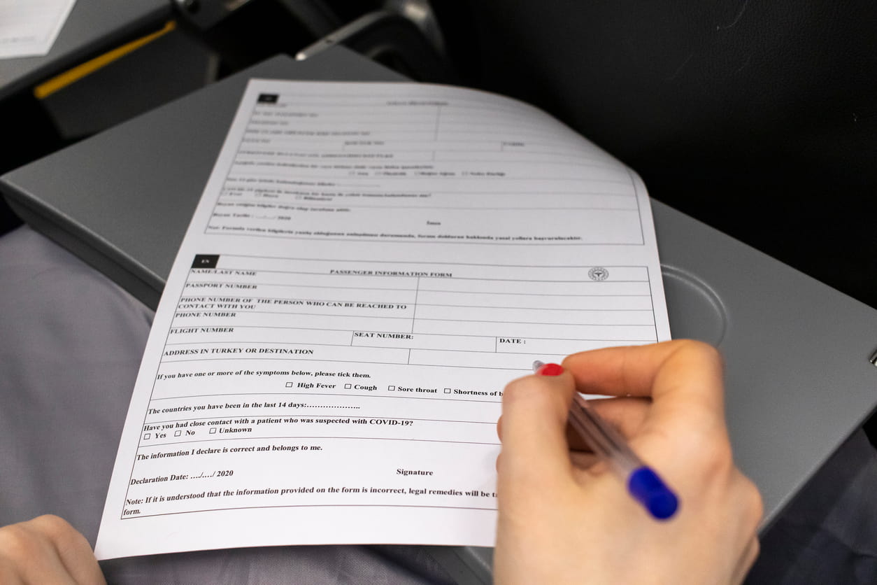 A person filling out a passenger information form, illustrating the documentation involved in a personal injury claim after a car accident.