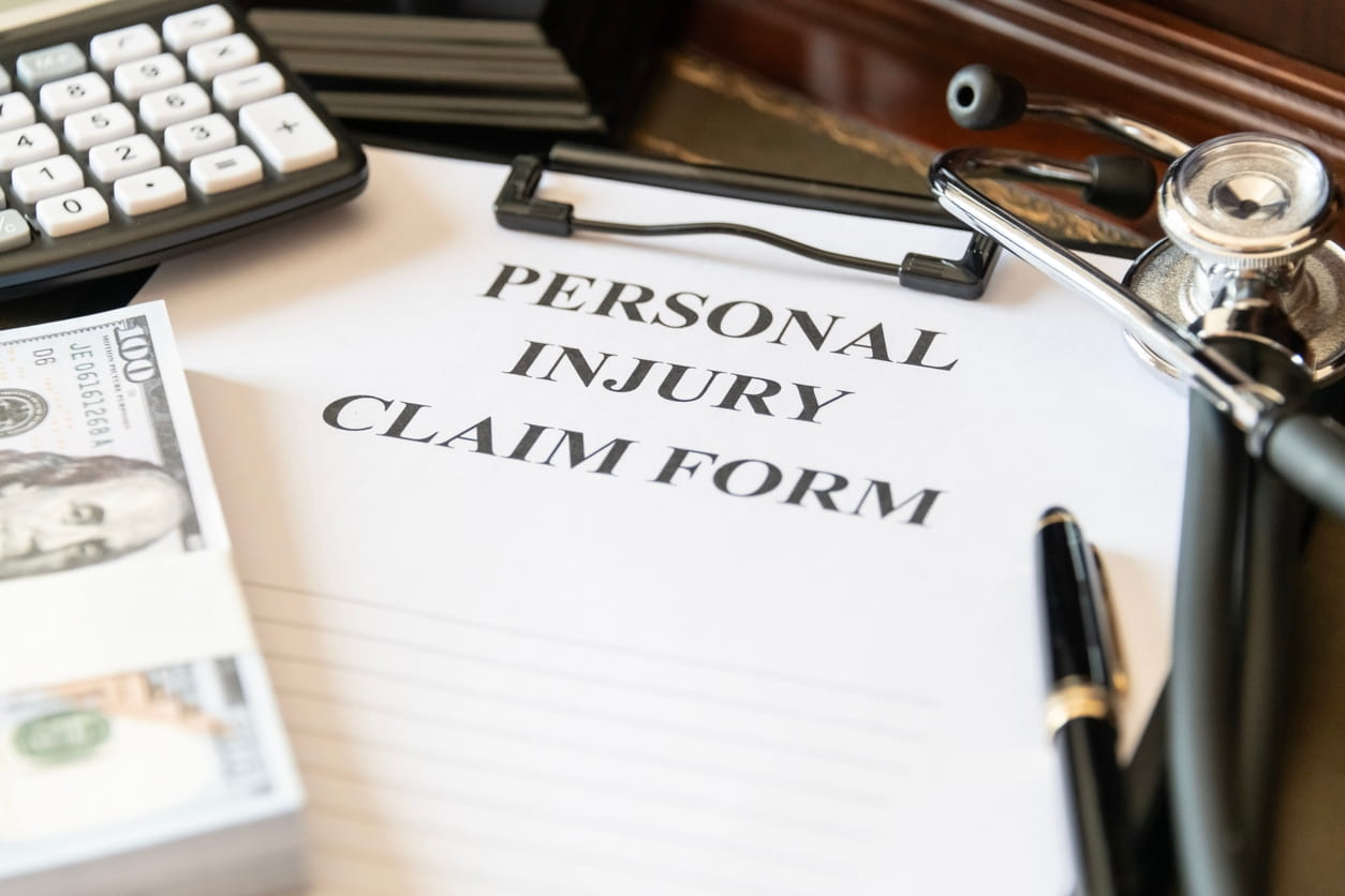 Personal injury claim form on a desk with a stethoscope and cash, highlighting environmental damage claims.