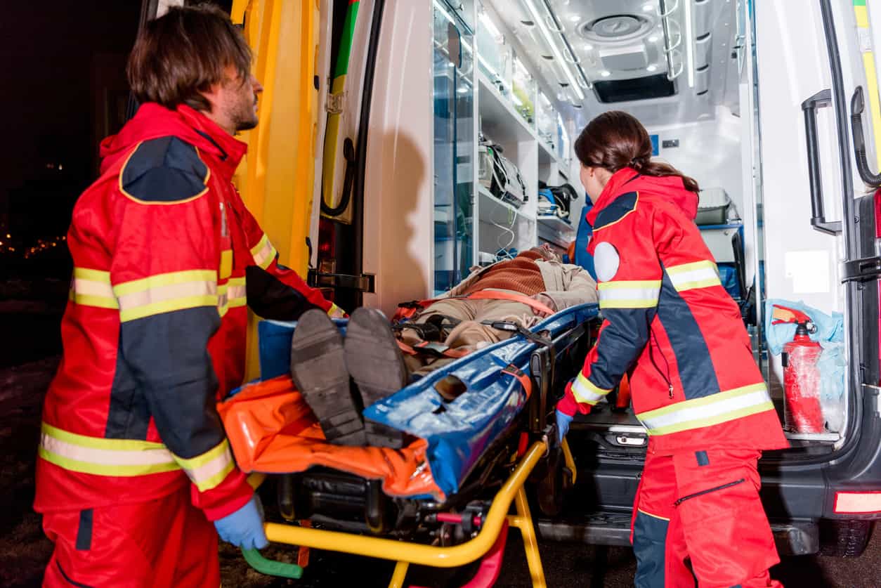 Emergency responders transporting an injured person to the hospital, emphasizing the importance of following medical instructions after a car accident injury.